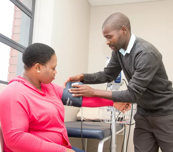 A man taking a woman's blood pressure.