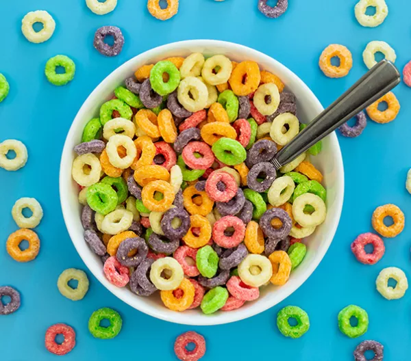 Colored breakfast cereal in a bowl on a blue background