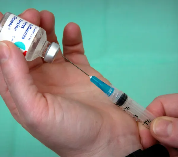 Flu vaccine being extracted from a vial