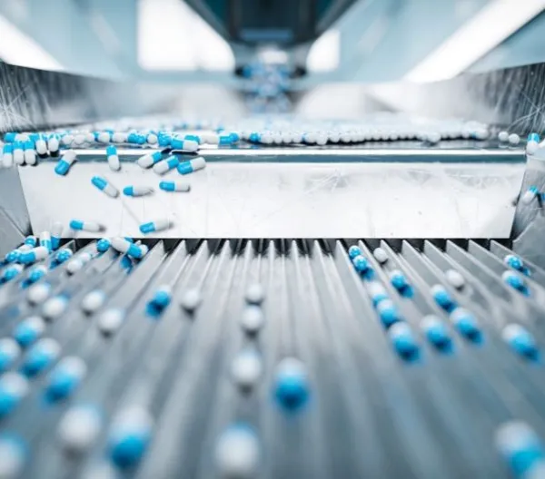 Blue and white capsules on a pharmaceutical sorting machine