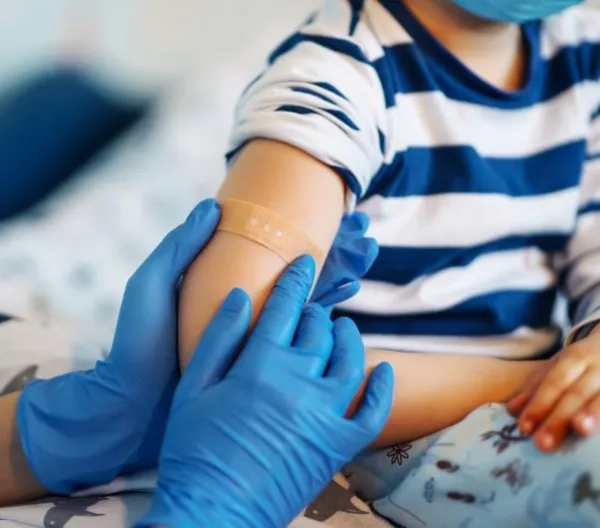 Children's doctor vaccinating little boy against common childhood diseases