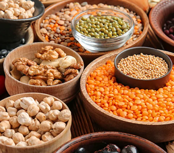 several wooden bowls fille with all different lentils and legumes
