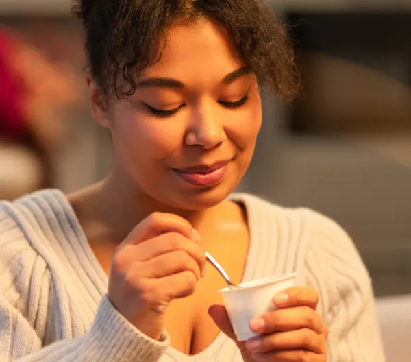 woman eating a cup of yogurt