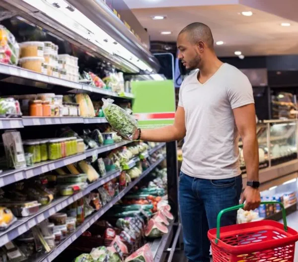 A man shops for bagged salad