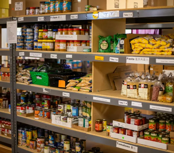 Food bank shelves containing dried and canned goods