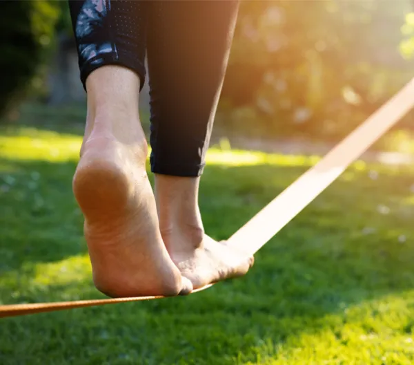 woman's feet walking on a tightrope low to the ground in a park