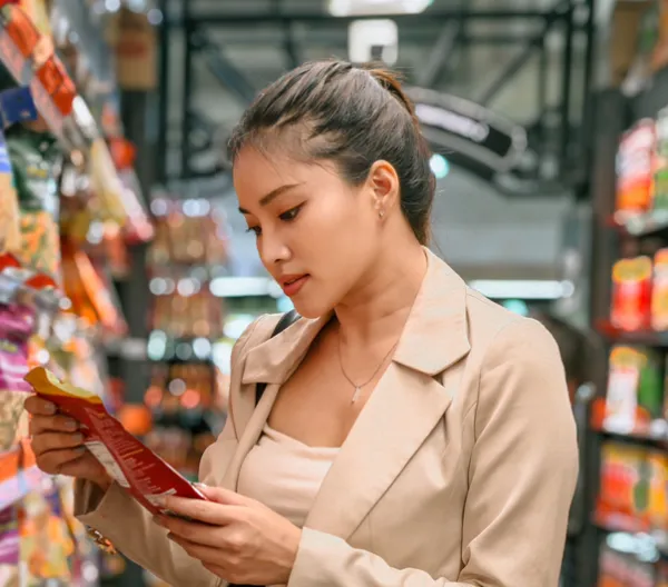 woman in grocery store looking at package of food