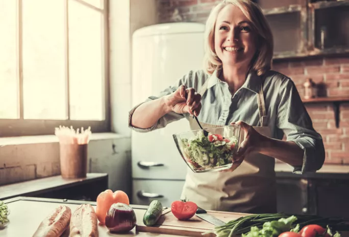 a middle aged woman making a salad