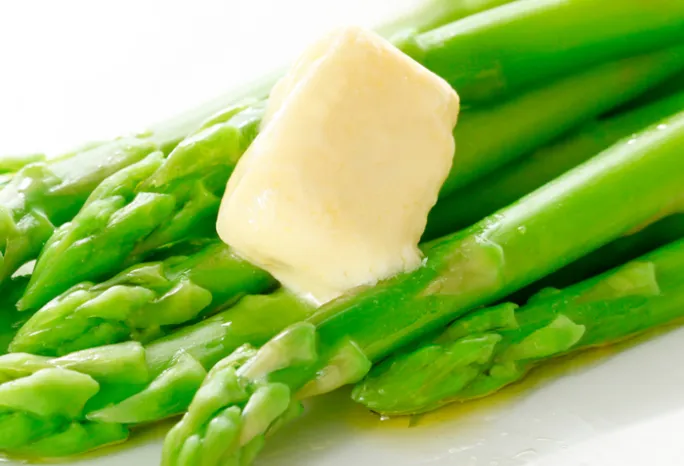 green asparagus stalks with melting pat of butter 