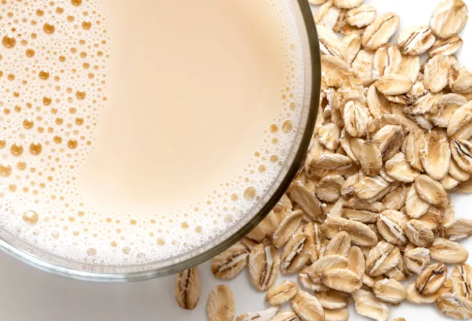 view from above, cup of oat milk with pile of oats next to it 