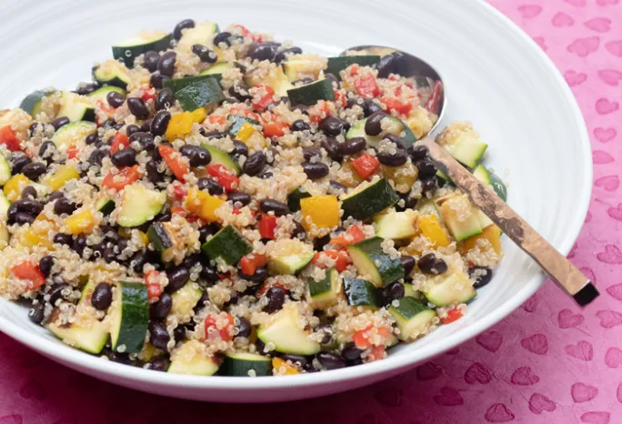 white bowl filled with black bean and quinoa and other vegetables