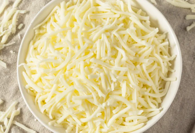 white bowl filled with light shredded cheese