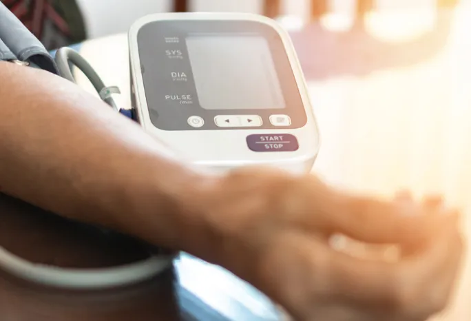 person using at at-home blood pressure monitor