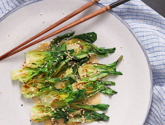 cooked bok choy with sesame sauce drizzled on top