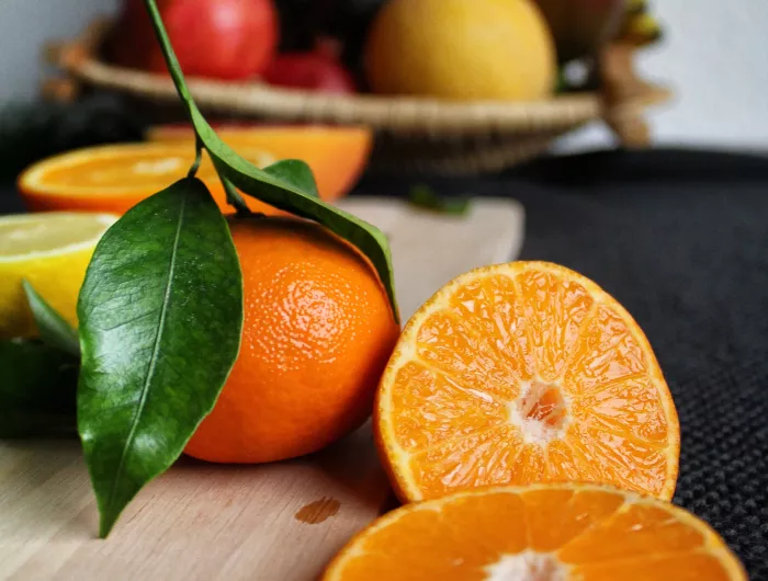 tangerines in front of a fruit bowl