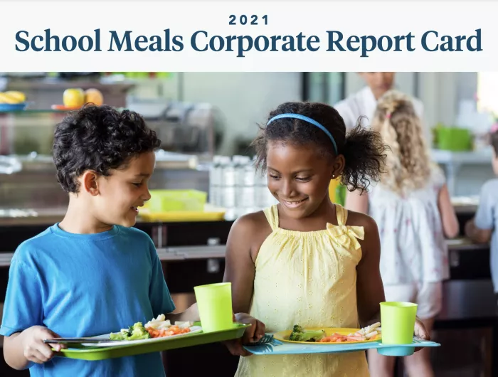 Two diverse children with school lunches