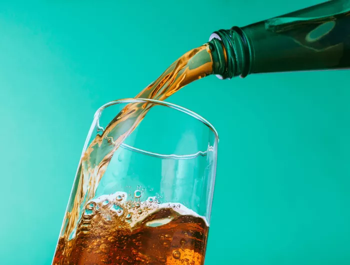 Pouring soda into a glass of ice