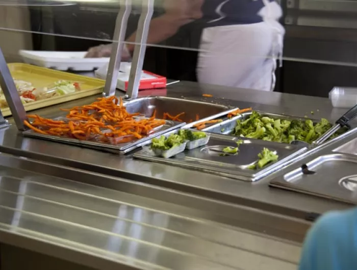 A buffet bar with steel hotel pans full of broccoli and sweet potato fries