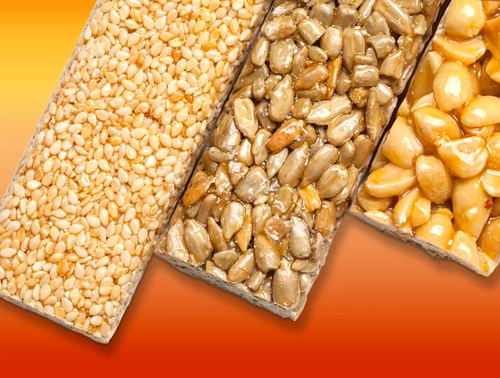 3 granola and nut bars on orange background