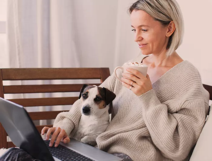 woman sitting with dog, sipping coffee