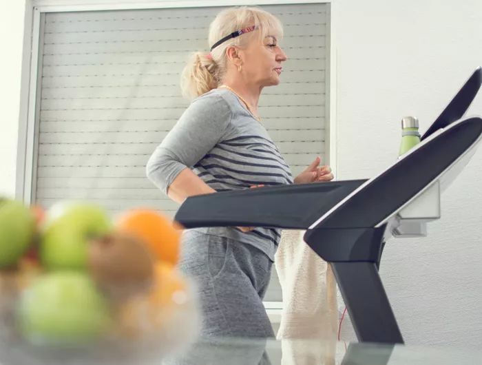 older woman walking on treadmill