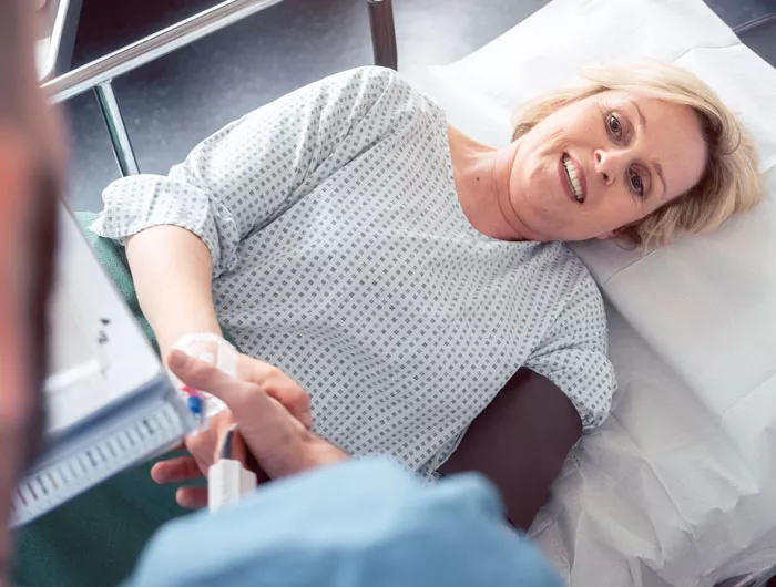 woman laying on hospital bed looking up at technician