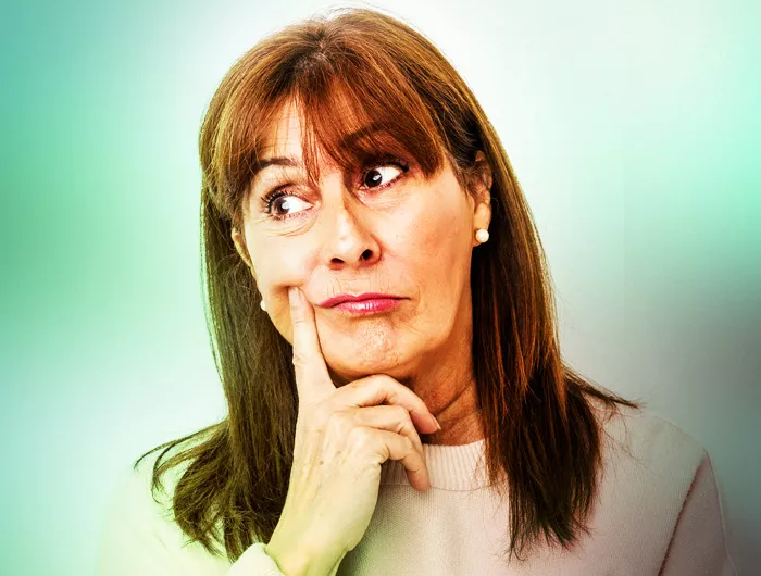 woman in a thinking position on blurred green background