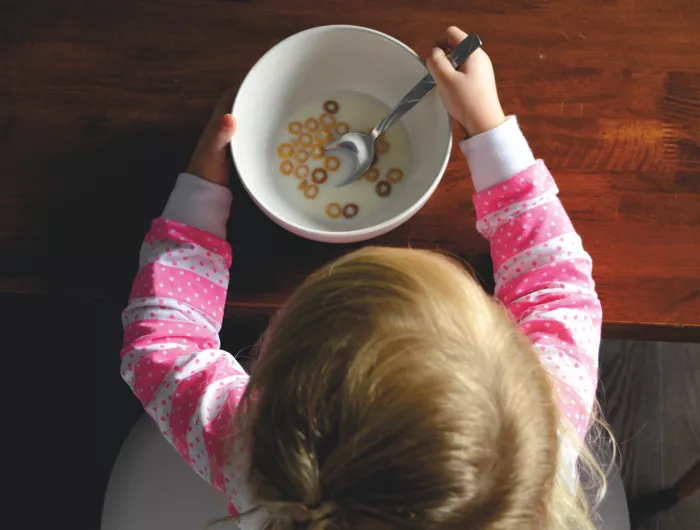 A child eating the last of her cereal.