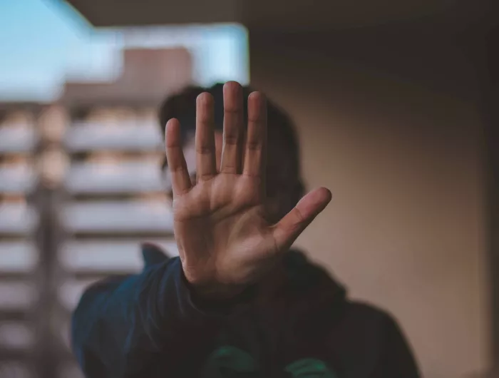 Man holding his hand up to signify "pause" or "stop"