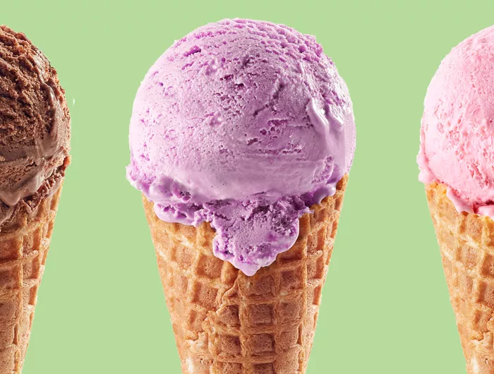 3 ice cream cones with one chocolate scoop, one purple scoop, one pink scoop on a green background.