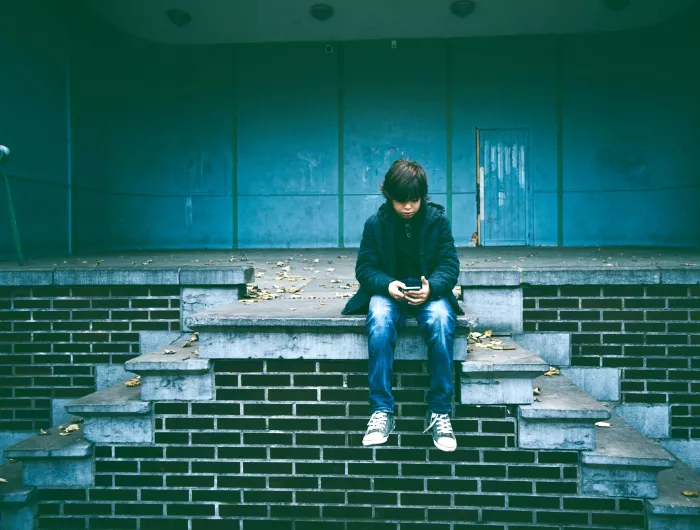 A middle school aged boy watching a video on his phone
