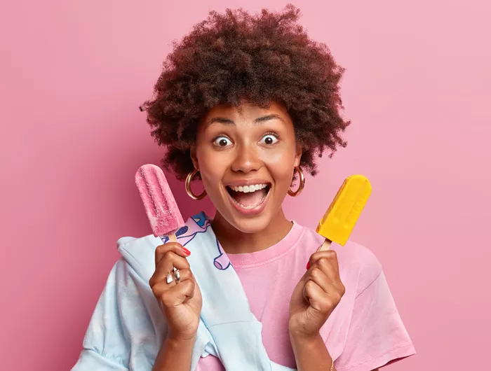 a woman holding popsicles