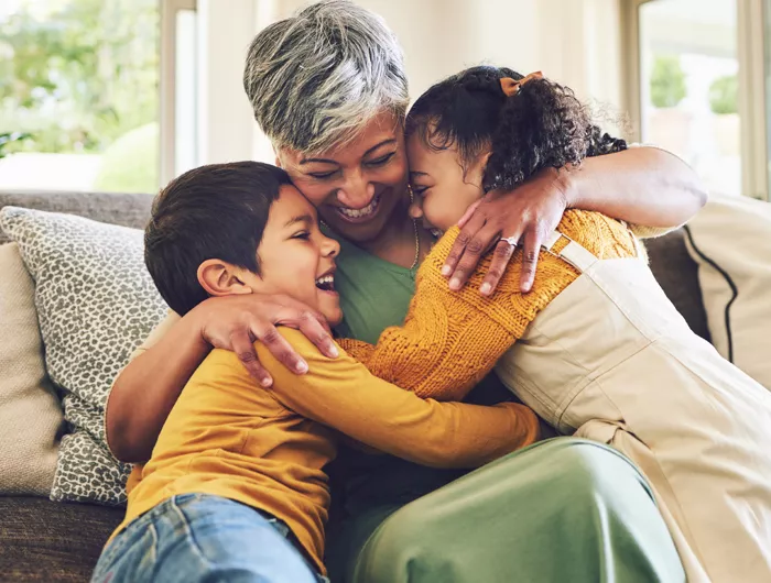 older woman hugging 2 younger children