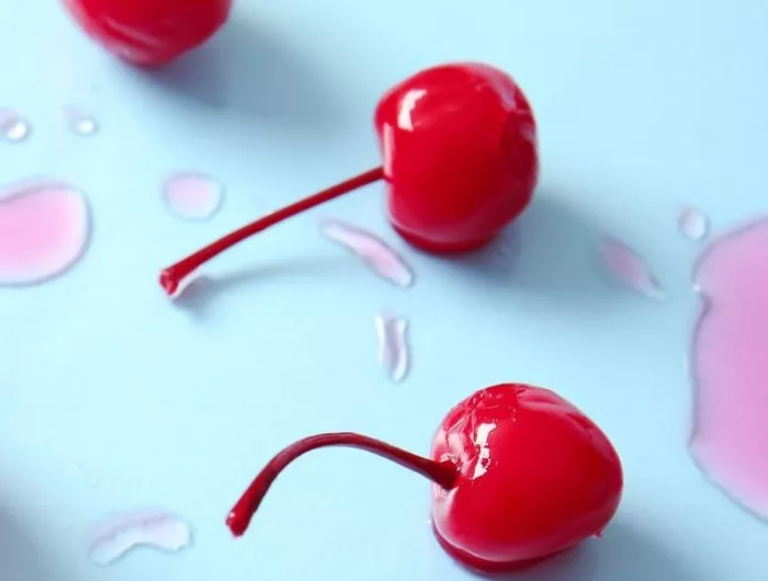 Maraschino cherries on a blue surface