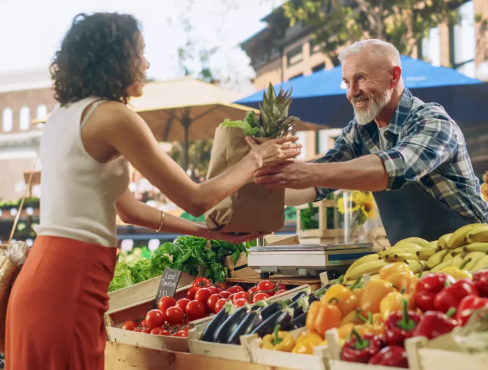 woman buying a pineapple at an outdoor farmers market