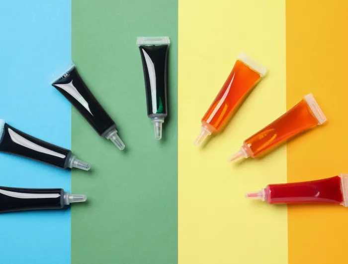Tubes of commercial food dyes on a rainbow background