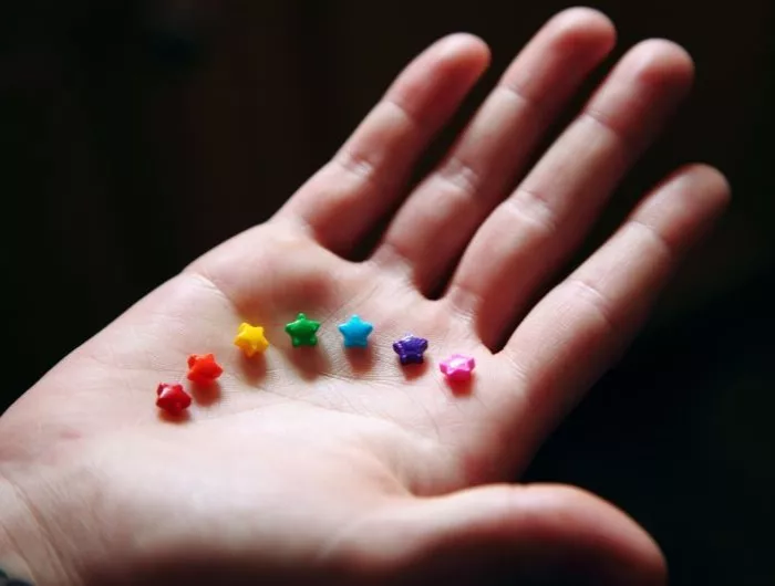 Brightly colored star-shaped sprinkles in a child's hand