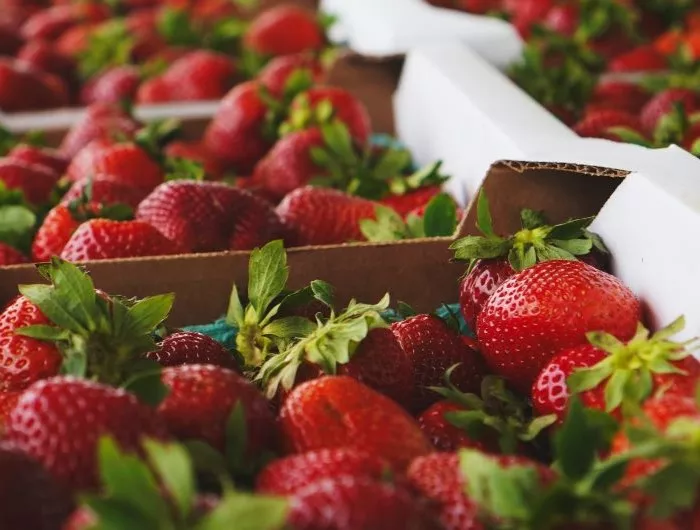 Seasonal produce - a closeup of carboard crates of strawberries for sale