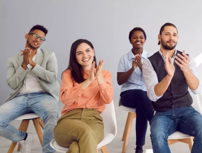 Adult male and female students applauding speaker 