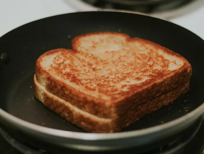 A well toasted grilled cheese sandwich in a frying pan.