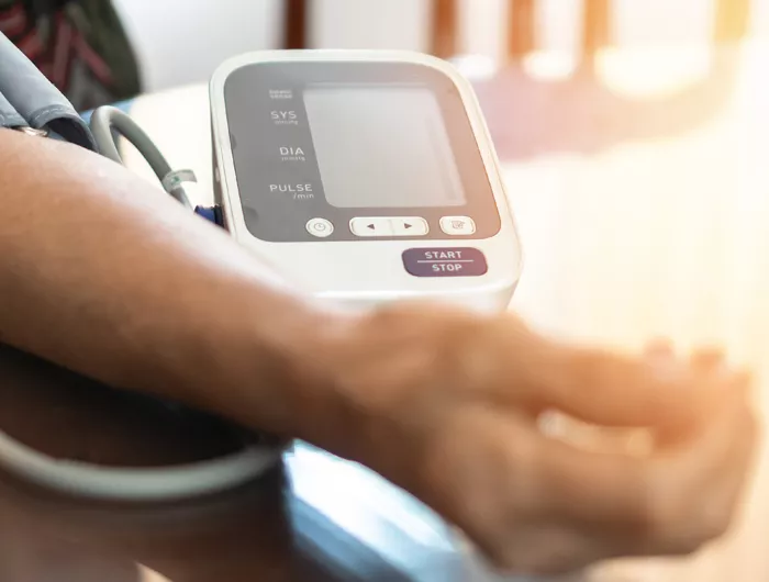 person using at at-home blood pressure monitor