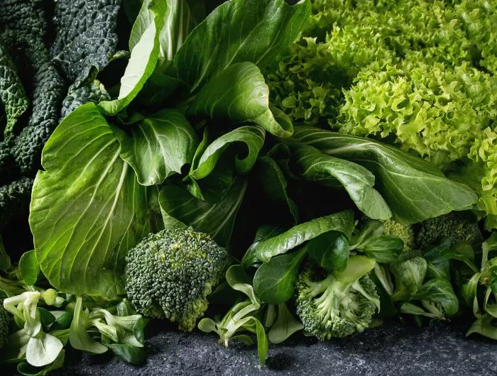 Seasonal produce - a closeup of broccoli, spinach, kale, and other leafy greens in season in December