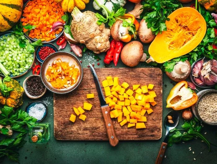 Sliced pumpkin, vegetables, mushrooms, root vegetables, spices, wood cutting board. Thanksgiving Day preparation. Healthy eating, slow food.