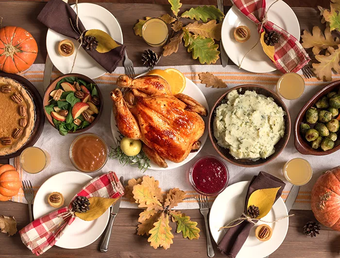 Thanksgiving meal with turkey, pecan pie, mashed potatoes, brussels sprouts, and salad