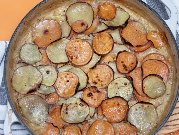 pan filled with scalloped potatoes in a sauce