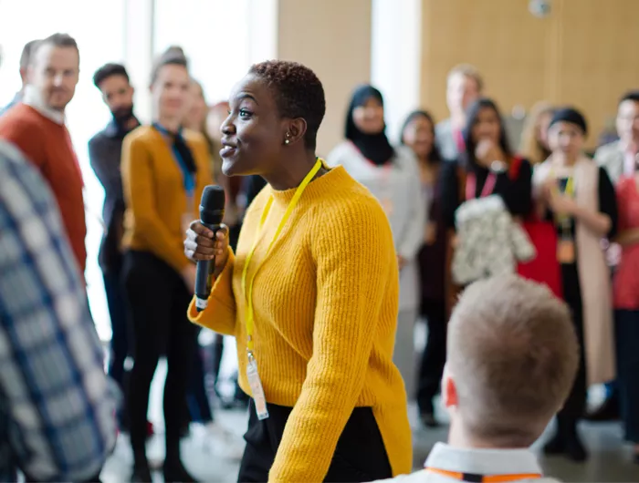 A woman speaking to a diverse group