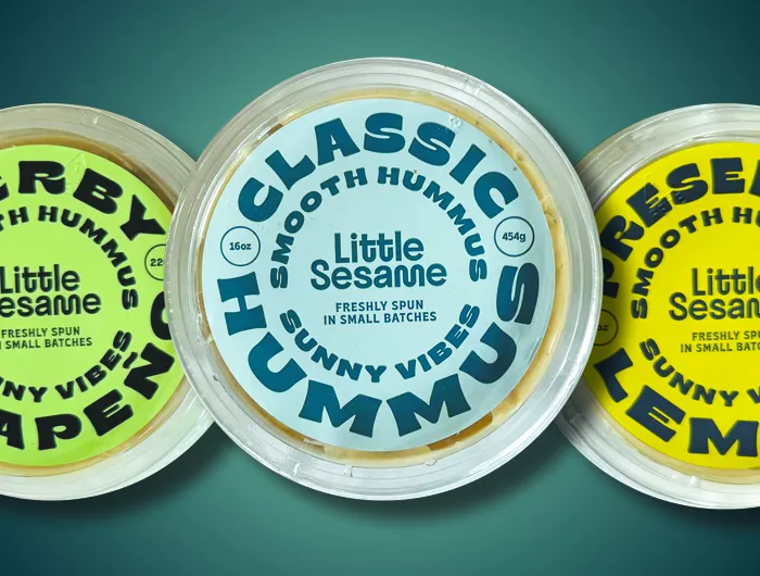 3 tubs of different flavors of Little Sesame hummus with original flavor in the middle.