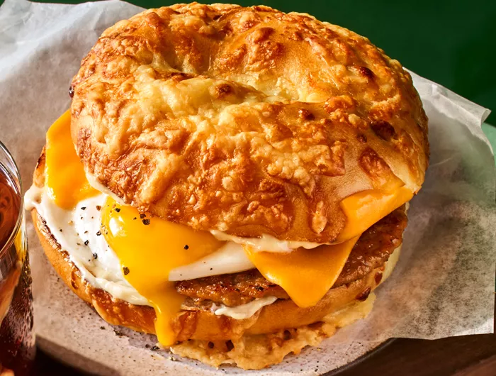 panera's asiago sausage & egg sandwich on a green background