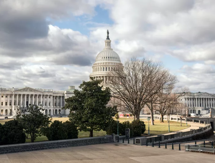 View of the Capitol Building against a cloudy sky from across the street
