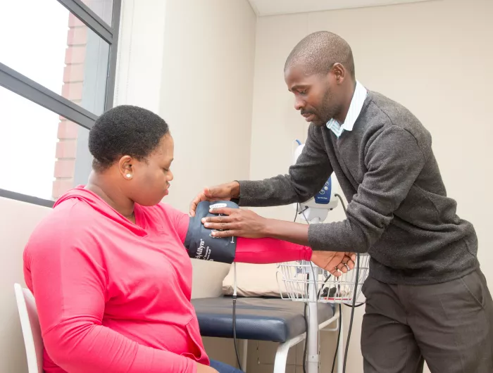 A man taking a woman's blood pressure.